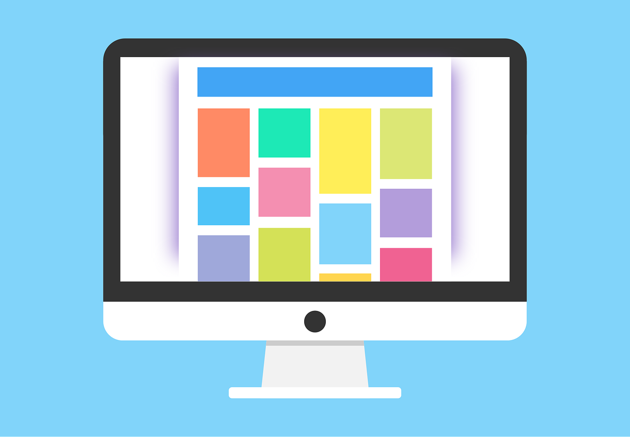 A computer monitor displays a colorful grid layout resembling a webpage with brightly colored rectangles against a blue background, conveying a modern, vibrant design.